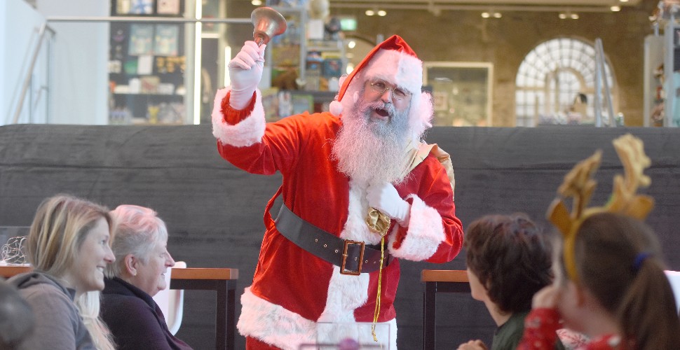 Father Christmas waving his bell at The Box during breakfast event